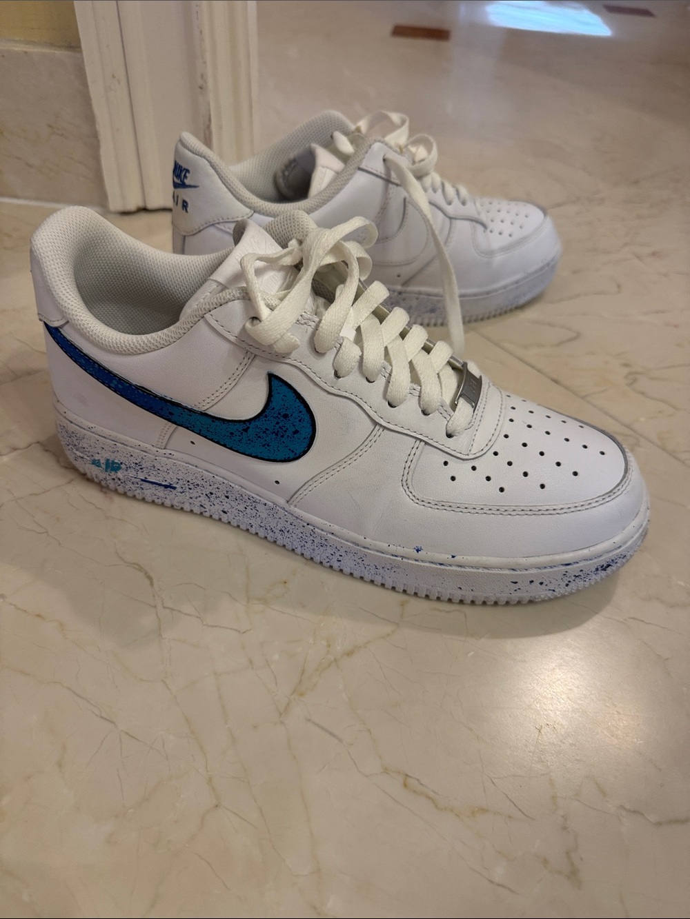 Nike White Low-Top Sneakers with Blue Speckled Swoosh